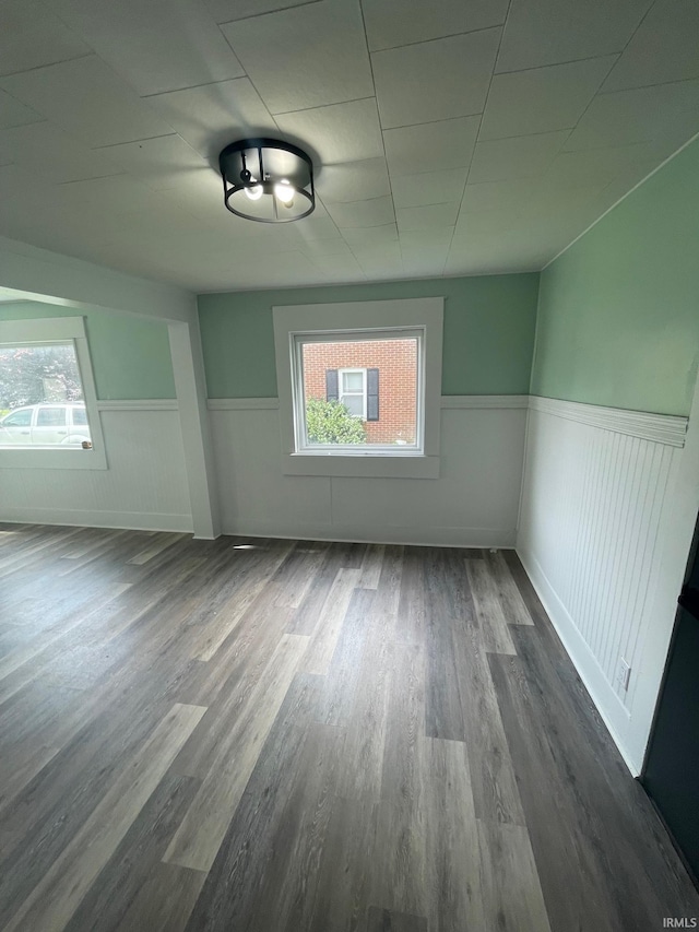 310 S Jefferson St, Bicknell, IN 47512 - empty room featuring a wainscoted wall, dark wood-style floors, and plenty of natural light