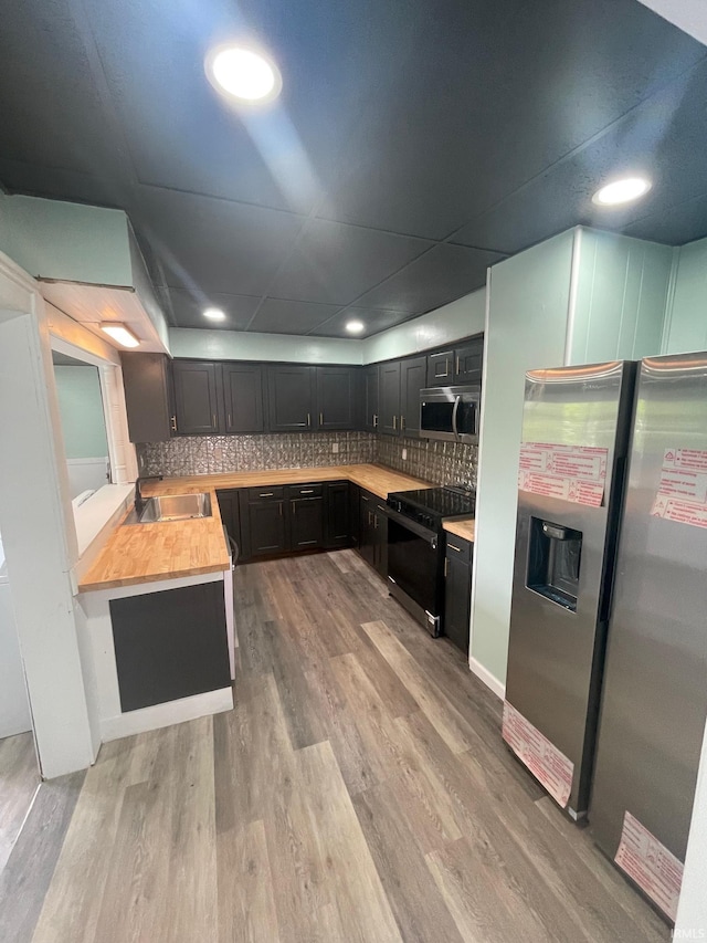 310 S Jefferson St, Bicknell, IN 47512 - kitchen with appliances with stainless steel finishes, dark cabinetry, backsplash, light wood-type flooring, and recessed lighting