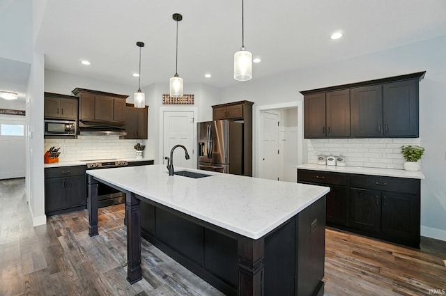 907 Switchfoot Dr, Huntertown, IN 46748 - kitchen with stainless steel appliances, under cabinet range hood, decorative backsplash, dark wood-style floors, and recessed lighting