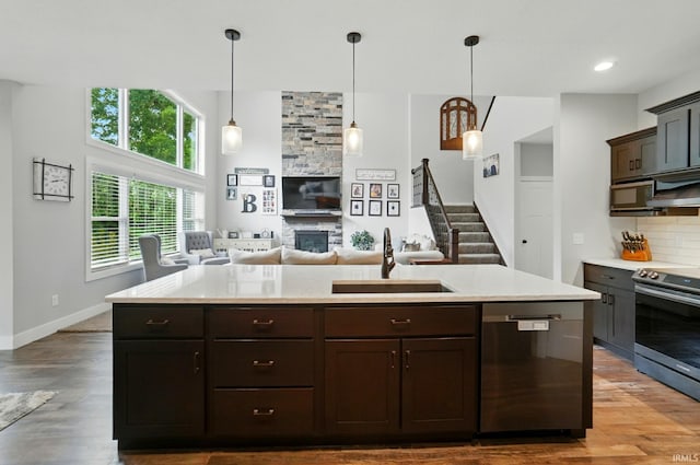 907 Switchfoot Dr, Huntertown, IN 46748 - kitchen featuring appliances with stainless steel finishes, a fireplace, light countertops, and dark brown cabinets