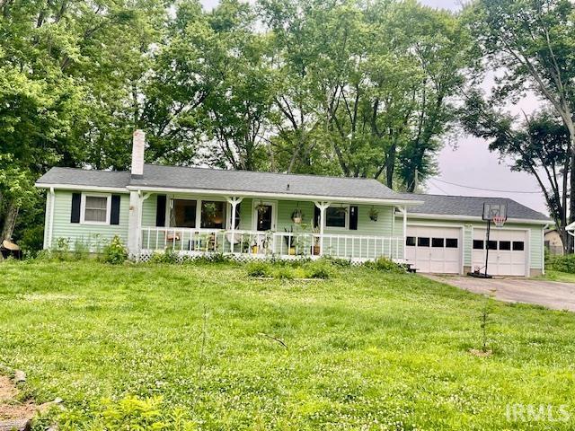 7210 W Dinsmore Rd, Bloomington, IN 47403 - single story home featuring a porch, a chimney, a garage, and a front lawn