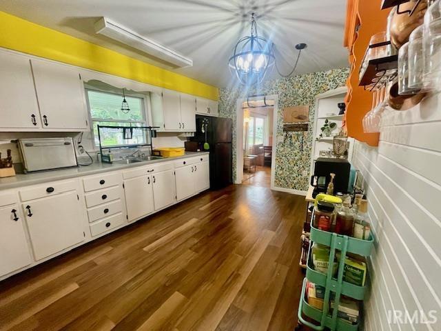 7210 W Dinsmore Rd, Bloomington, IN 47403 - kitchen featuring freestanding refrigerator, white cabinets, light countertops, dark wood finished floors, and wallpapered walls
