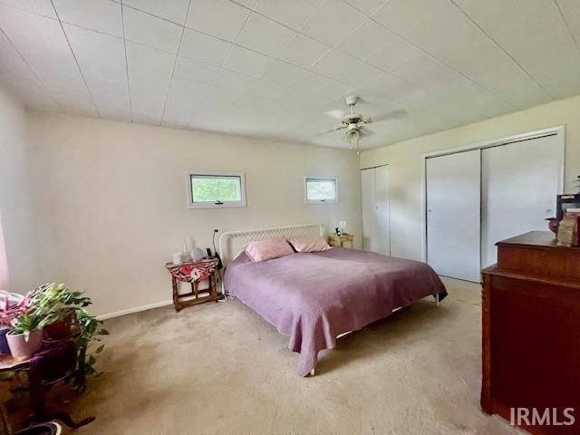 7210 W Dinsmore Rd, Bloomington, IN 47403 - bedroom featuring two closets, carpet floors, and a ceiling fan