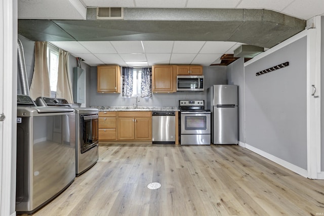 867 Park Plaza Dr, Evansville, IN 47715 - kitchen featuring appliances with stainless steel finishes, separate washer and dryer, a paneled ceiling, light wood-style flooring, and healthy amount of natural light