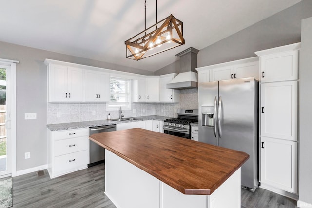 509 Janewood Ct, Goshen, IN 46526 - kitchen featuring stainless steel appliances, custom range hood, wooden counters, lofted ceiling, and decorative backsplash