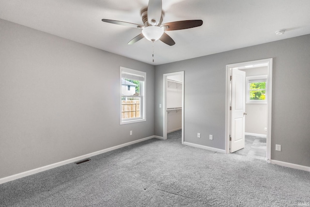 509 Janewood Ct, Goshen, IN 46526 - unfurnished bedroom with multiple windows, a spacious closet, carpet flooring, and a ceiling fan