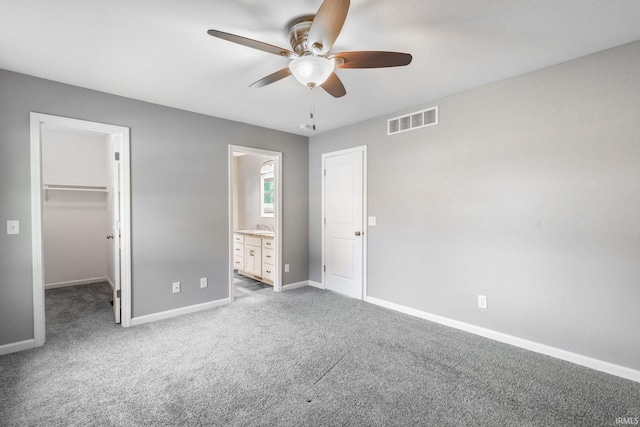 509 Janewood Ct, Goshen, IN 46526 - unfurnished bedroom featuring a spacious closet, carpet floors, ensuite bath, ceiling fan, and a closet