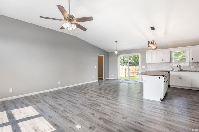 509 Janewood Ct, Goshen, IN 46526 - kitchen featuring lofted ceiling, open floor plan, butcher block countertops, white cabinetry, and backsplash