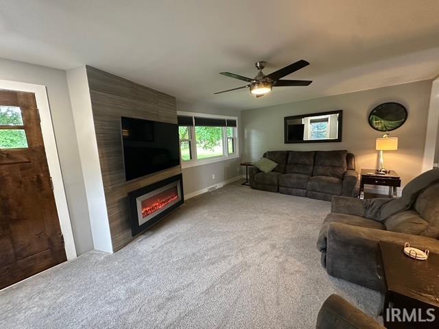 32131 State Road 2nd Rd, New Carlisle, IN 46552 - carpeted living room with a fireplace and ceiling fan