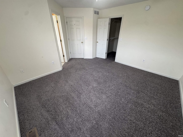 3832 E Cobble Creek Dr, Bloomington, IN 47401 - unfurnished bedroom with dark colored carpet and a walk in closet