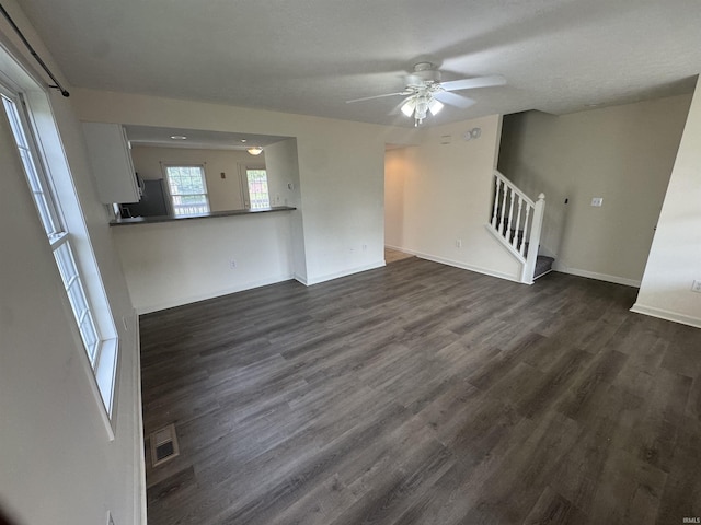 3832 E Cobble Creek Dr, Bloomington, IN 47401 - unfurnished living room with stairs, ceiling fan, and dark wood finished floors