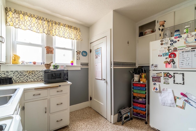 2130 N Wells St, Fort Wayne, IN 46808 - kitchen featuring freestanding refrigerator, black microwave, light countertops, stove, and a textured ceiling