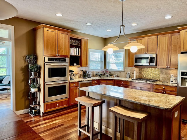3638 Swansea Dr, West Lafayette, IN 47906 - kitchen featuring appliances with stainless steel finishes, healthy amount of natural light, wood finished floors, backsplash, and a textured ceiling