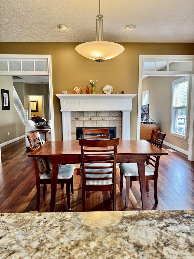 3638 Swansea Dr, West Lafayette, IN 47906 - dining room featuring a tiled fireplace, wood finished floors, a textured ceiling, and recessed lighting