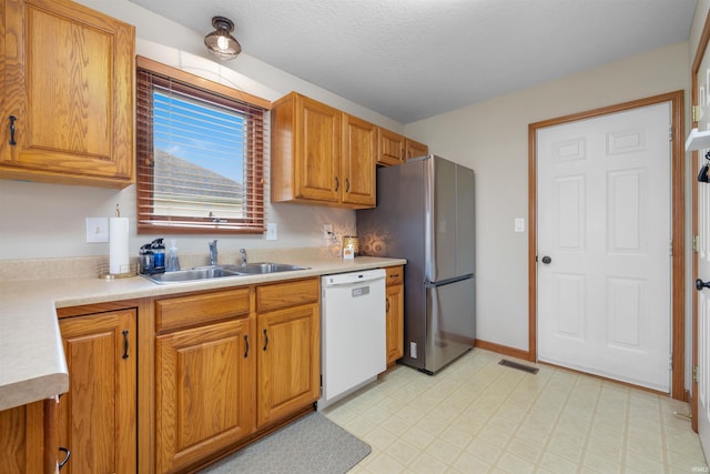 5371 Bear Creek Pass, Auburn, IN 46706 - kitchen with dishwasher, freestanding refrigerator, light countertops, light flooring, and brown cabinets