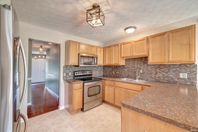 4539 N Shadow Wood Dr, Bloomington, IN 47404 - kitchen with stainless steel appliances, light brown cabinetry, decorative backsplash, dark countertops, and a textured ceiling