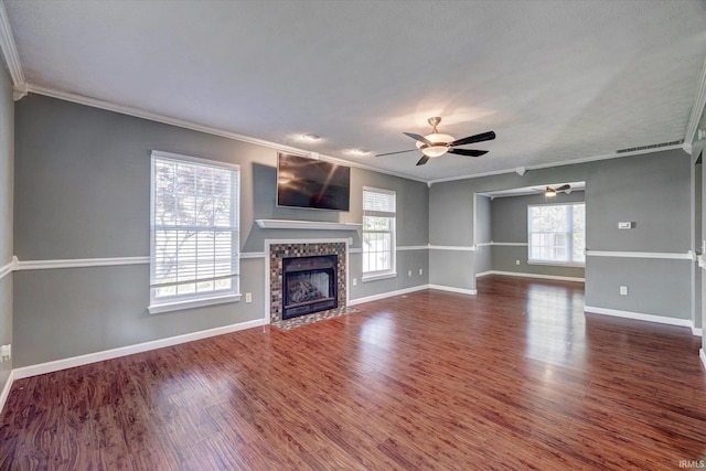 4539 N Shadow Wood Dr, Bloomington, IN 47404 - unfurnished living room featuring crown molding, ceiling fan, a tiled fireplace, and dark wood-type flooring
