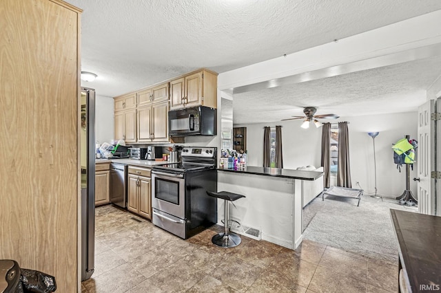2514 Wood St, Elkhart, IN 46514 - kitchen with stainless steel appliances, a textured ceiling, a ceiling fan, and light brown cabinetry
