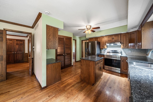 17112 Ridgefield Ct, Granger, IN 46530 - kitchen featuring appliances with stainless steel finishes, under cabinet range hood, a kitchen island, ceiling fan, and wood finished floors