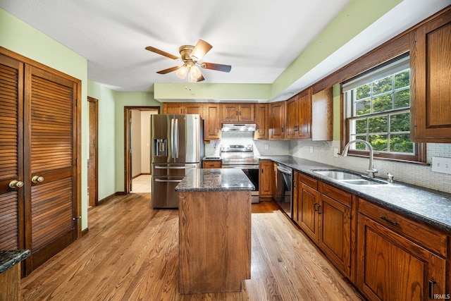 17112 Ridgefield Ct, Granger, IN 46530 - kitchen with stainless steel appliances, a center island, light wood-style flooring, and tasteful backsplash
