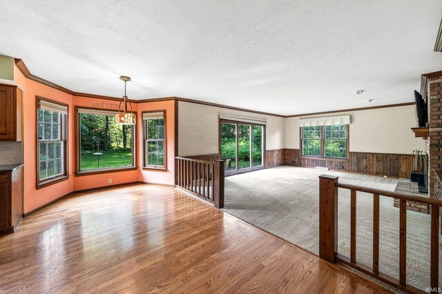 17112 Ridgefield Ct, Granger, IN 46530 - unfurnished living room with wood finished floors, a textured ceiling, wainscoting, ornamental molding, and a fireplace