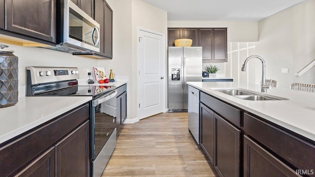 12967 Solo Ln, Fort Wayne, IN 46818 - kitchen featuring appliances with stainless steel finishes, light wood-style flooring, light countertops, and dark brown cabinets