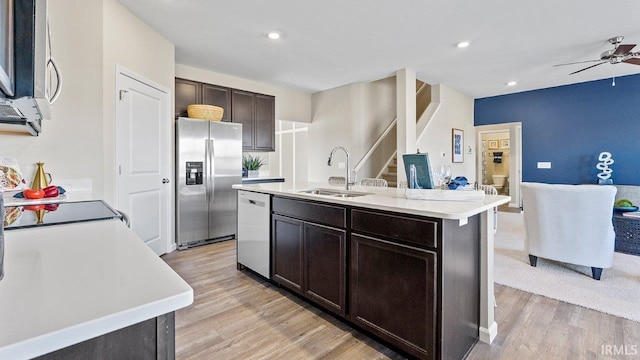 12967 Solo Ln, Fort Wayne, IN 46818 - kitchen with stainless steel appliances, light countertops, ceiling fan, open floor plan, and light wood-style floors