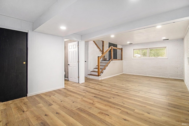 60220 Ruby St, South Bend, IN 46614 - below grade area featuring light wood-style floors, stairway, brick wall, and recessed lighting