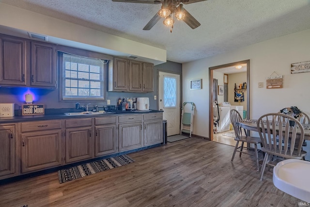 272 Sherman St, Wabash, IN 46992 - kitchen with washing machine and clothes dryer, dark countertops, a textured ceiling, dark wood finished floors, and a ceiling fan