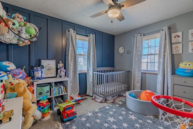 272 Sherman St, Wabash, IN 46992 - carpeted bedroom with a textured ceiling, a nursery area, and a ceiling fan