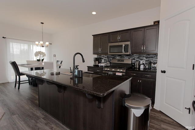 13710 Copper Strike Pass, Fort Wayne, IN 46845 - kitchen with stainless steel appliances, a chandelier, a breakfast bar, tasteful backsplash, and dark wood-style floors