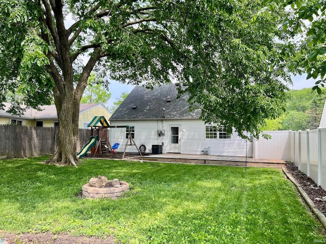 2927 Barnhart Ave, Fort Wayne, IN 46805 - back of house featuring a playground, a fenced backyard, a shingled roof, and a fire pit