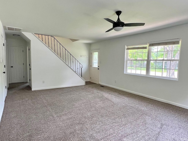 2927 Barnhart Ave, Fort Wayne, IN 46805 - unfurnished living room featuring ceiling fan, stairs, and carpet