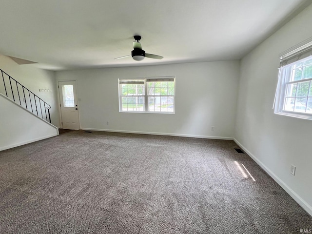 2927 Barnhart Ave, Fort Wayne, IN 46805 - unfurnished living room featuring healthy amount of natural light, a ceiling fan, carpet, and stairway