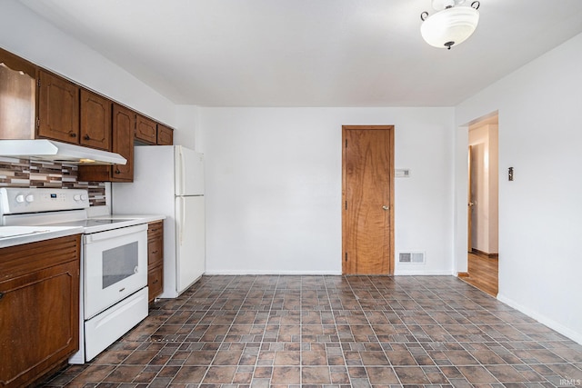 429 S Edison Ave, South Bend, IN 46619 - kitchen with white appliances, under cabinet range hood, tasteful backsplash, light countertops, and stone finish flooring