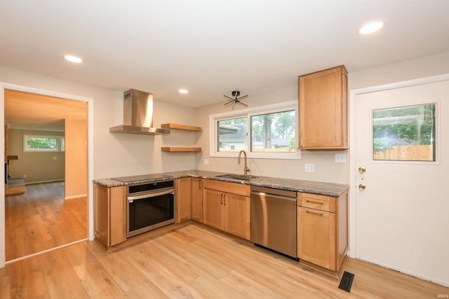 5219 Forest Grove Dr, Fort Wayne, IN 46835 - kitchen featuring appliances with stainless steel finishes, wall chimney exhaust hood, open shelves, light wood-style flooring, and dark stone countertops