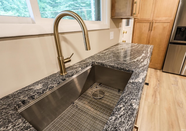 5219 Forest Grove Dr, Fort Wayne, IN 46835 - kitchen view of stainless steel refrigerator with ice dispenser, dark stone countertops, and light wood-type flooring