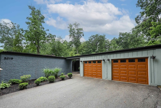 5219 Forest Grove Dr, Fort Wayne, IN 46835 - view of front of property with board and batten siding, a garage, and driveway