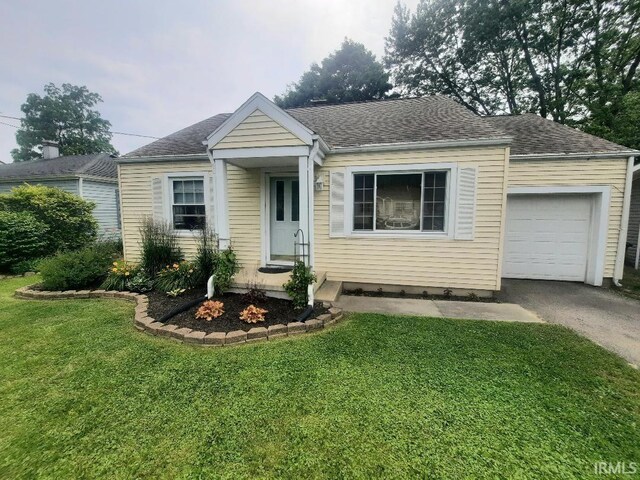 2629 S Meeker Ave, Muncie, IN 47302 - view of front of home featuring an attached garage, a front lawn, driveway, and roof with shingles
