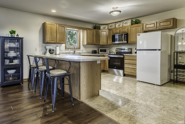 8005 Mackinac Cv, Fort Wayne, IN 46835 - kitchen with appliances with stainless steel finishes, a breakfast bar, recessed lighting, a peninsula, and light countertops