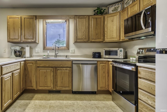 8005 Mackinac Cv, Fort Wayne, IN 46835 - kitchen with stainless steel appliances, brown cabinetry, and light countertops