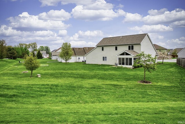 8005 Mackinac Cv, Fort Wayne, IN 46835 - back of house featuring a lawn, a sunroom, and roof with shingles