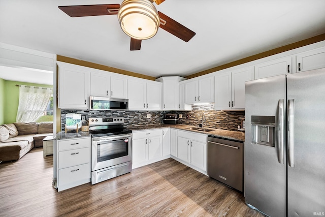 3822 Eastmont Dr, South Bend, IN 46628 - kitchen with appliances with stainless steel finishes, ceiling fan, backsplash, white cabinetry, and wood finished floors