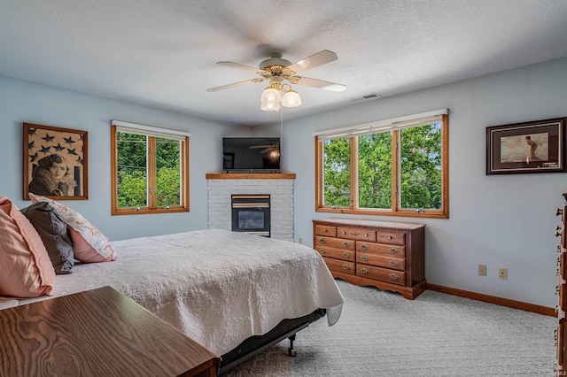 1209 S Jackson St, Auburn, IN 46706 - carpeted bedroom with multiple windows, a fireplace, a ceiling fan, and a textured ceiling