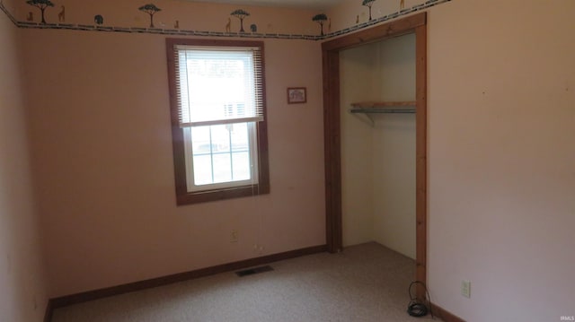 142 W Howard St, Galveston, IN 46932 - unfurnished bedroom featuring multiple windows, a closet, and light carpet