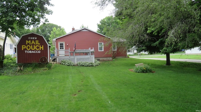 142 W Howard St, Galveston, IN 46932 - view of property exterior featuring a chimney, a yard, and a wooden deck