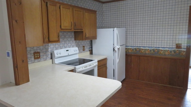 142 W Howard St, Galveston, IN 46932 - kitchen with white appliances, wallpapered walls, brown cabinetry, a peninsula, and light countertops