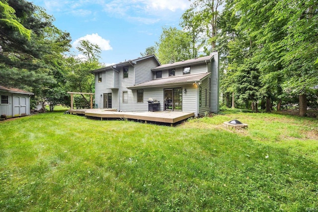 10880 Cougar Dr, Granger, IN 46530 - rear view of house with an outdoor fire pit, a chimney, a deck, a lawn, and a storage unit