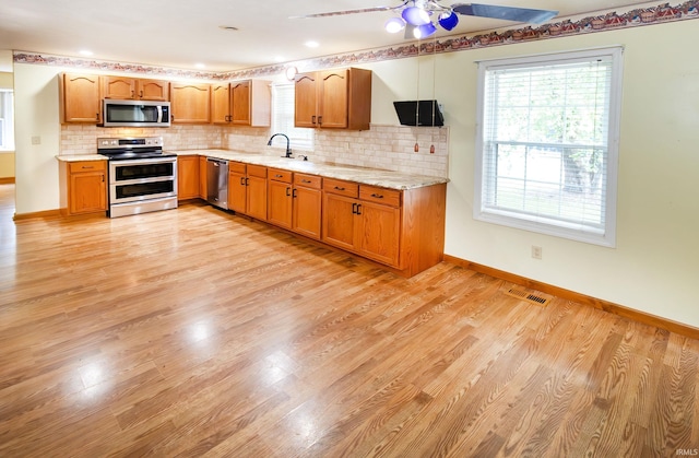 9040 Clear Creek Dr, Evansville, IN 47711 - kitchen featuring stainless steel appliances, ceiling fan, backsplash, and plenty of natural light