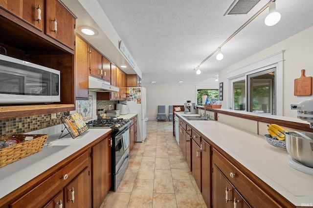 2107 W 450 S, Lafayette, IN 47909 - kitchen featuring appliances with stainless steel finishes, under cabinet range hood, backsplash, light countertops, and a textured ceiling